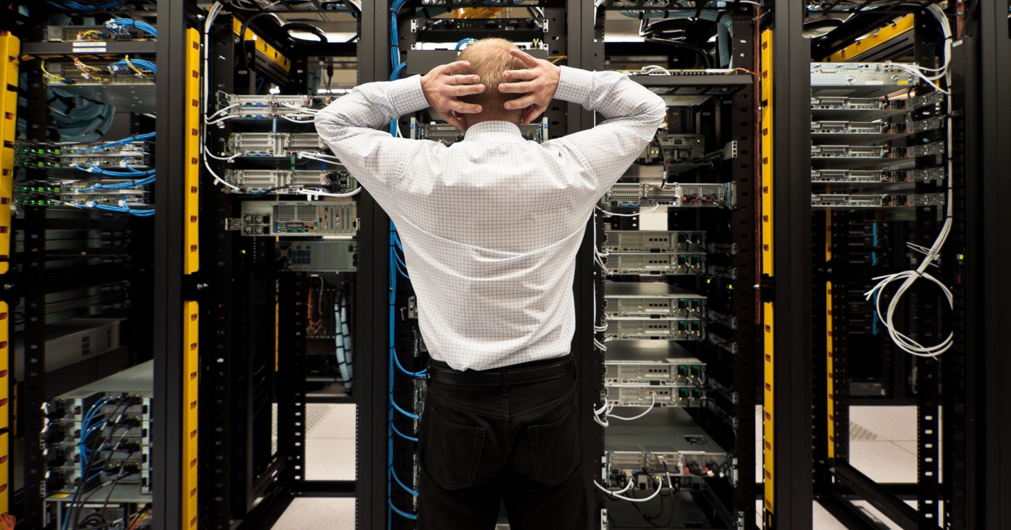 Ein Serverraum in Unordnung, rote Warnleuchten blinken und symbolisieren einen IT-Notfall oder Datenverlust.